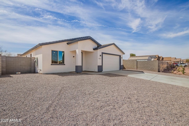 single story home with a garage, concrete driveway, fence, and stucco siding