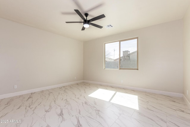 empty room featuring marble finish floor, a ceiling fan, visible vents, and baseboards