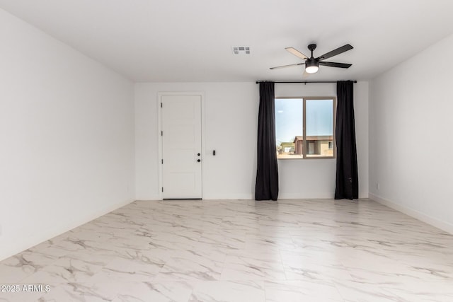 spare room featuring a ceiling fan, marble finish floor, visible vents, and baseboards