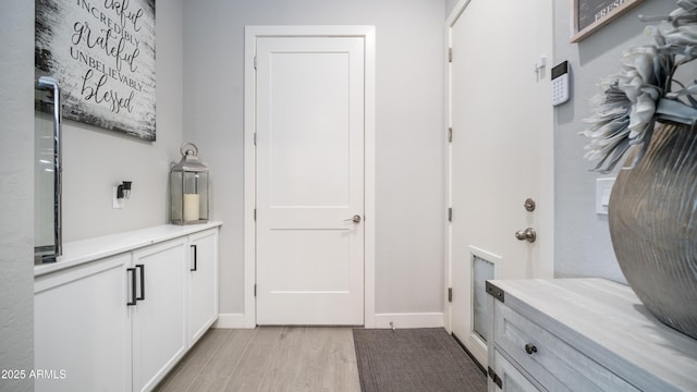 mudroom featuring light wood-style floors and baseboards