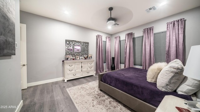 bedroom featuring ceiling fan, wood finished floors, visible vents, and baseboards