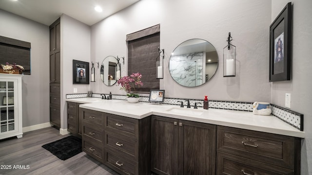 full bathroom with walk in shower, wood finished floors, vanity, and baseboards