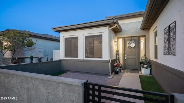 view of exterior entry featuring stucco siding