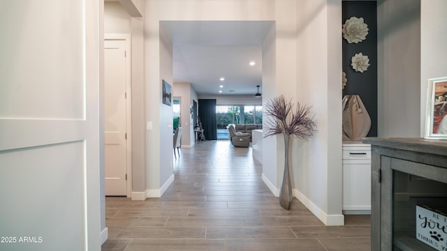 hall featuring recessed lighting, wine cooler, baseboards, and wood finish floors