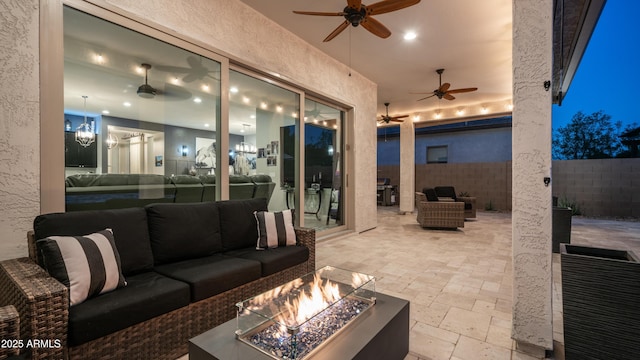 view of patio / terrace with an outdoor living space with a fire pit, fence, and a ceiling fan