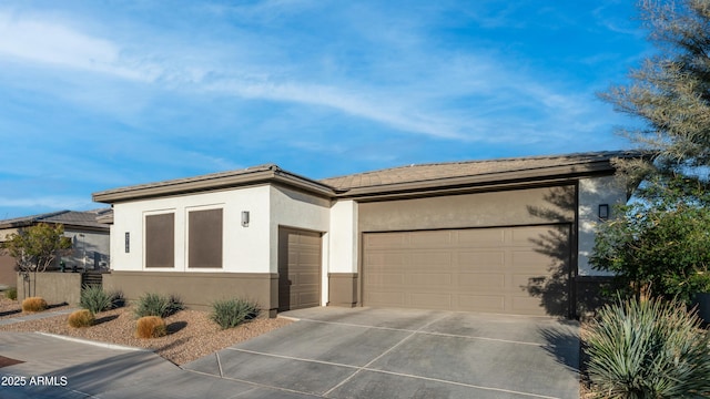 view of front of home featuring a garage, driveway, and stucco siding