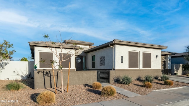 view of front of home featuring fence and stucco siding