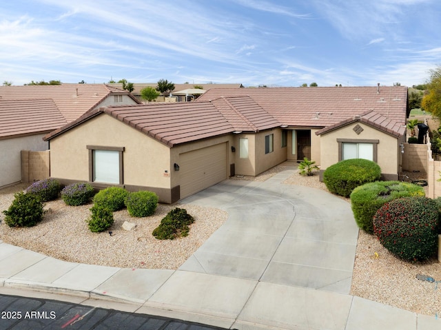 ranch-style home featuring a tiled roof, stucco siding, concrete driveway, and an attached garage