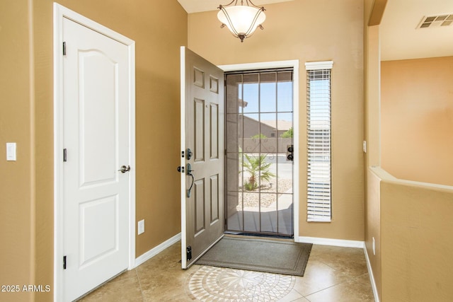 tiled entrance foyer with visible vents and baseboards