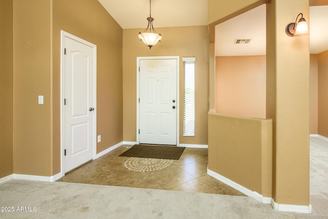 entrance foyer with tile patterned floors, visible vents, carpet floors, and baseboards