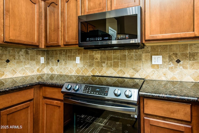 kitchen with dark stone countertops, range with electric cooktop, brown cabinets, and stainless steel microwave