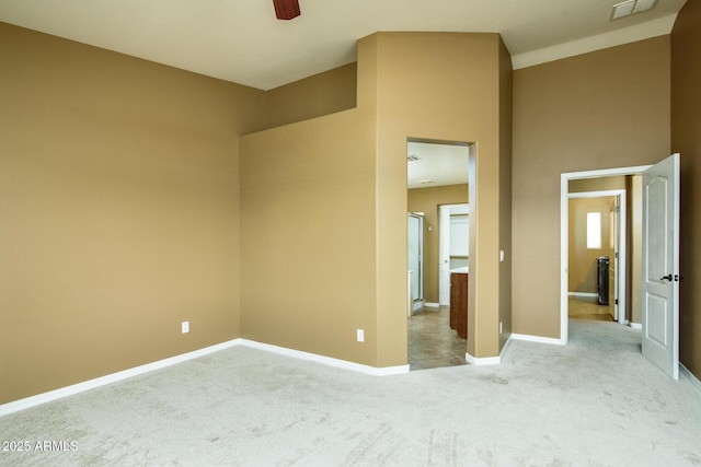unfurnished room featuring baseboards, visible vents, ceiling fan, and light colored carpet