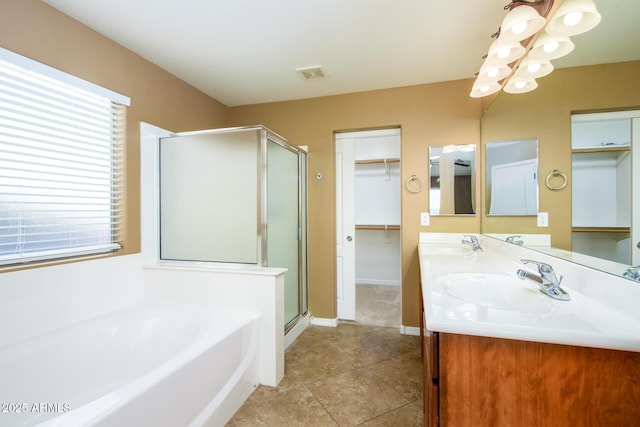 bathroom with visible vents, plenty of natural light, a stall shower, and a sink