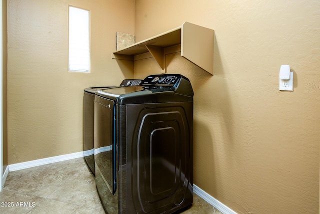 washroom with baseboards, laundry area, and independent washer and dryer