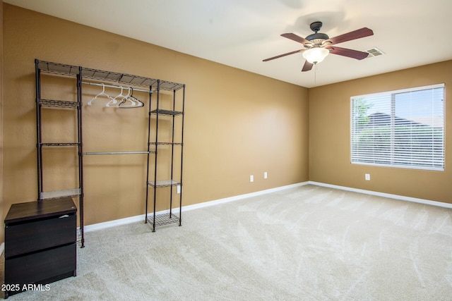 unfurnished room featuring carpet flooring, visible vents, ceiling fan, and baseboards
