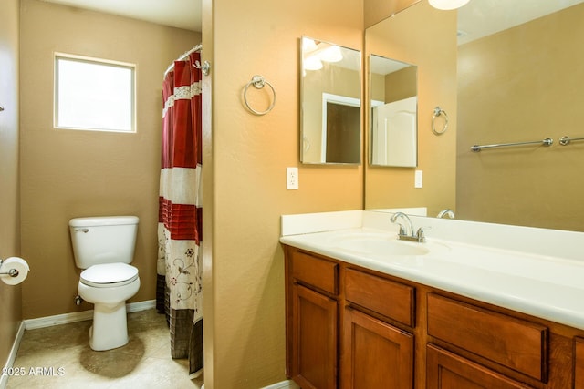 bathroom with vanity, toilet, tile patterned flooring, and baseboards