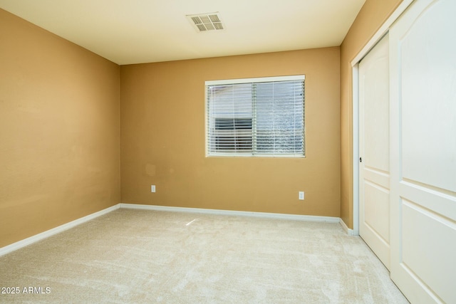 unfurnished bedroom with a closet, visible vents, carpet, and baseboards