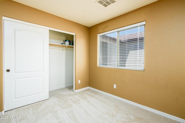 unfurnished bedroom with visible vents, a closet, baseboards, and carpet floors