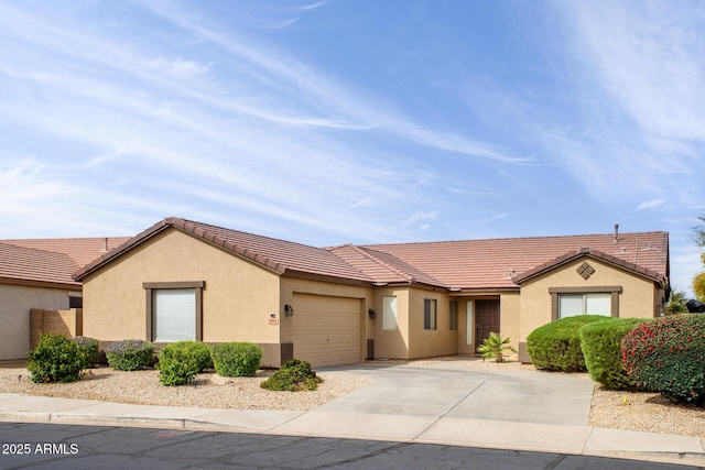 ranch-style house with stucco siding, a tiled roof, concrete driveway, and a garage