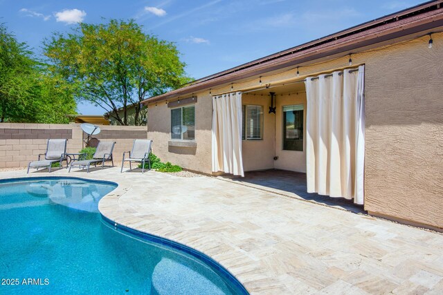 view of swimming pool featuring fence, a fenced in pool, and a patio area