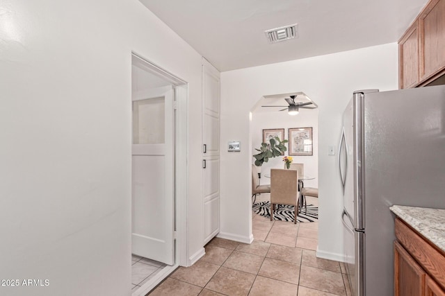 kitchen featuring stainless steel refrigerator, ceiling fan, and light tile patterned floors