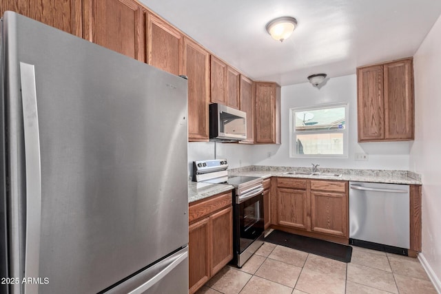 kitchen featuring light tile patterned floors, stainless steel appliances, and sink