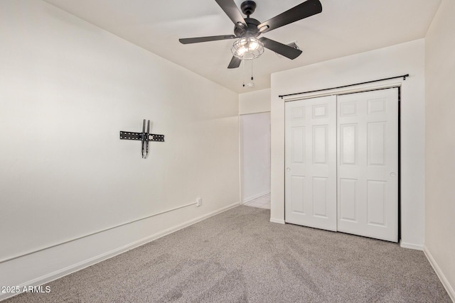 unfurnished bedroom featuring light carpet, ceiling fan, and a closet