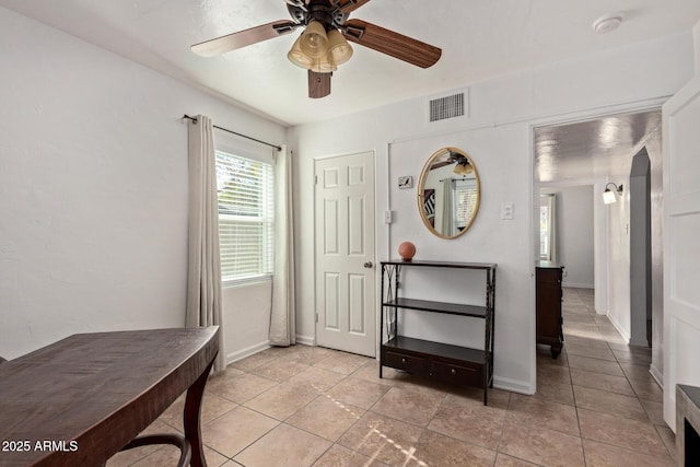 entryway featuring light tile patterned floors and ceiling fan