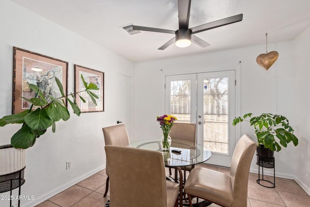 tiled dining room featuring ceiling fan and french doors