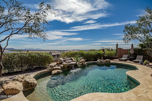 view of swimming pool with a patio area, fence, a mountain view, and a fenced in pool