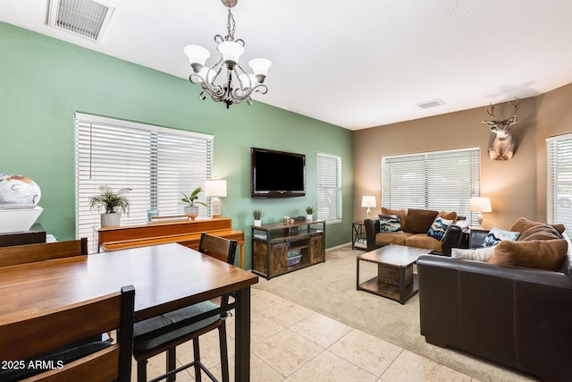 living area featuring light tile patterned flooring, visible vents, a notable chandelier, and light colored carpet