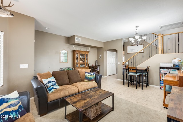 living area with visible vents, arched walkways, baseboards, light colored carpet, and stairs