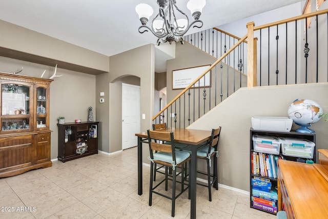 dining room with arched walkways, a chandelier, baseboards, stairs, and tile patterned floors