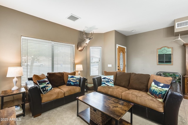 living area featuring visible vents and light carpet