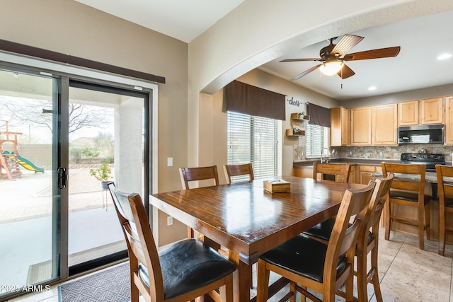 dining space with light tile patterned floors, arched walkways, a ceiling fan, and recessed lighting