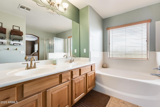 ensuite bathroom with double vanity, visible vents, a sink, and tile patterned floors