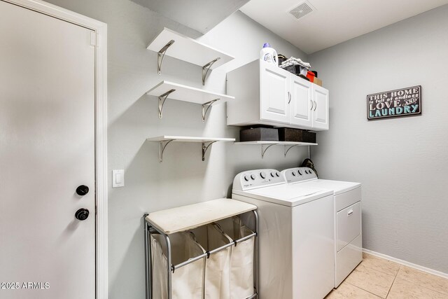 laundry room featuring cabinet space, visible vents, baseboards, washing machine and clothes dryer, and light tile patterned flooring