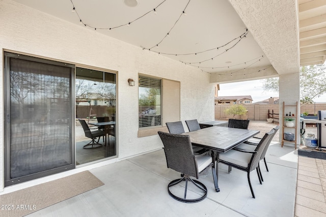 view of patio featuring outdoor dining area and fence