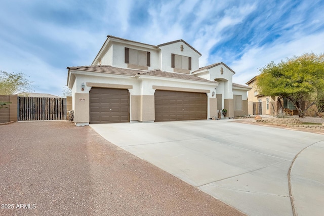 view of front of property with a tile roof, stucco siding, concrete driveway, a gate, and a garage