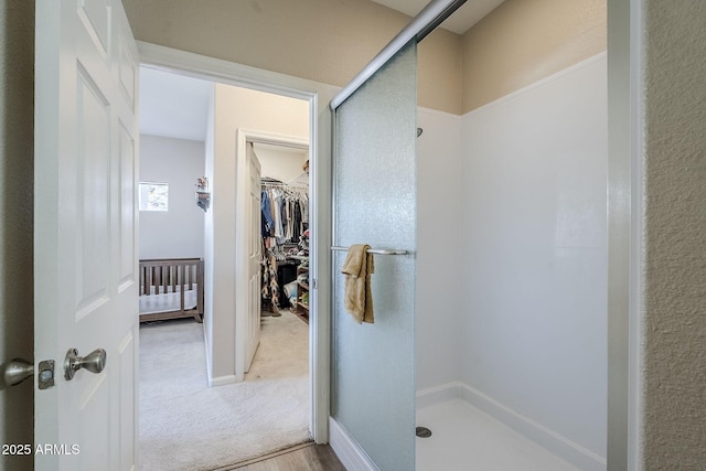 full bathroom featuring a stall shower and a walk in closet