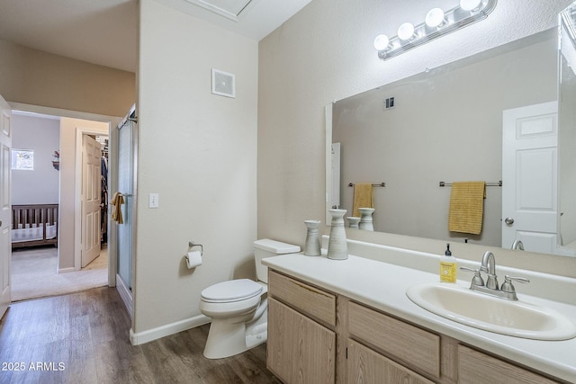 bathroom featuring toilet, visible vents, vanity, and wood finished floors