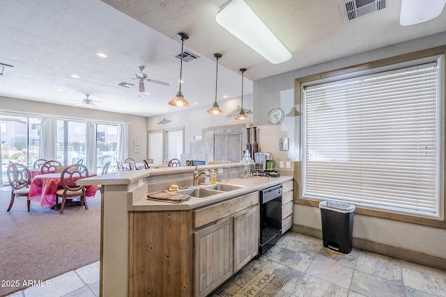 kitchen with a sink, visible vents, dishwasher, and a peninsula