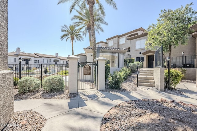 view of front of home featuring a residential view, a gate, stucco siding, and fence