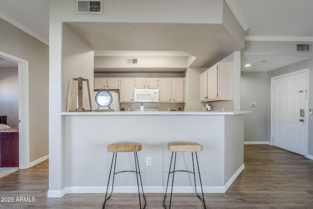 kitchen with dark wood-style floors, white microwave, and visible vents