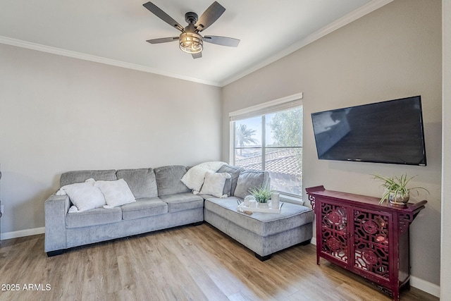 living room featuring a ceiling fan, crown molding, baseboards, and wood finished floors