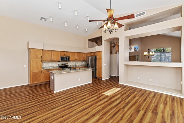 kitchen with ceiling fan with notable chandelier, dark wood-type flooring, visible vents, appliances with stainless steel finishes, and brown cabinets