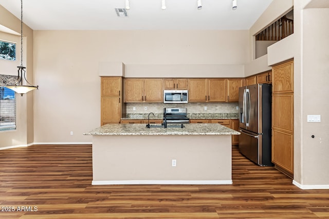 kitchen featuring a sink, tasteful backsplash, stainless steel appliances, and dark wood-type flooring