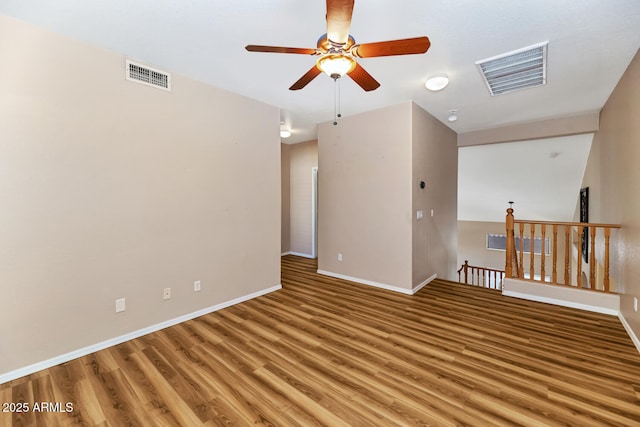 empty room with light wood-style flooring, visible vents, and baseboards