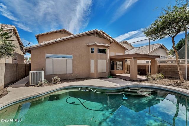 rear view of house featuring a fenced in pool, a patio, stucco siding, central AC, and a fenced backyard