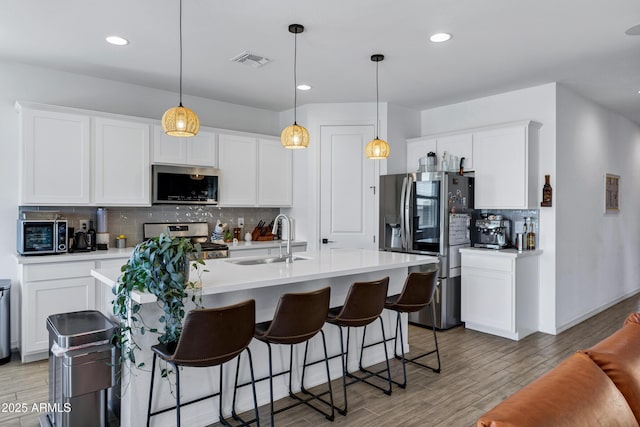6145 S Adelle, Mesa, AZ 85212 - kitchen featuring appliances with stainless steel finishes, a sink, decorative backsplash, light wood finished floors, and light countertops